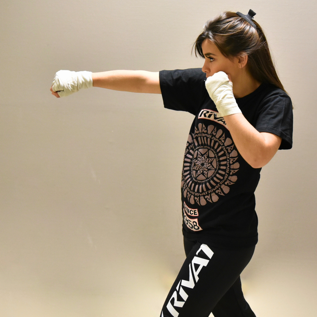 Femme pratiquant un direct en boxe avec des bandages aux mains pour montrer comment améliorer son direct en boxe