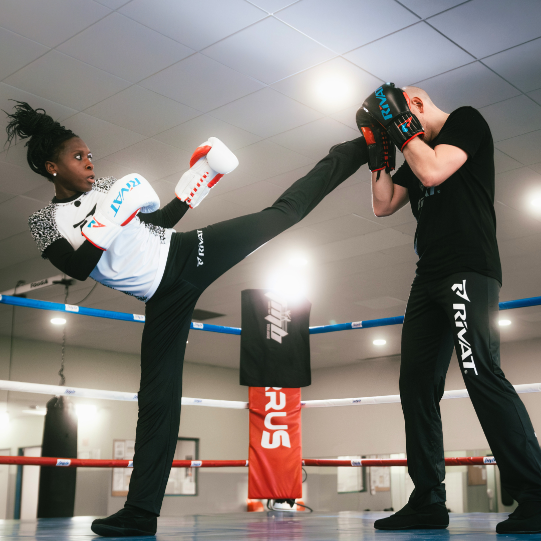 Femme pratiquant la boxe avec un coup de pied latéral en salle d'entraînement comment faire un coup de pied latéral