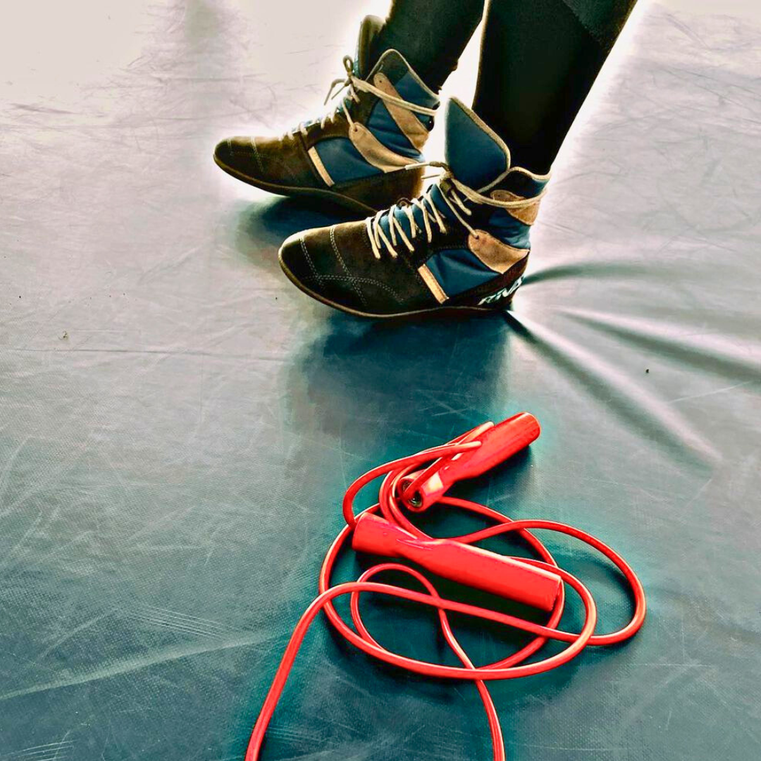 Comment choisir chaussures de boxe performantes avec des chaussures de boxe montantes et une corde à sauter rouge