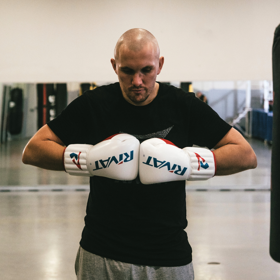 Boxeur en gants en position de blocage montrant comment améliorer sa garde au combat en boxe française