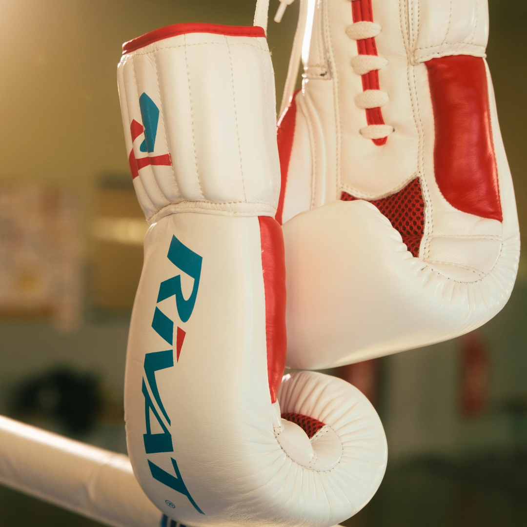 Gants de boxe française blancs et rouges illustrant comment préparer ses équipements pour une compétition de boxe française
