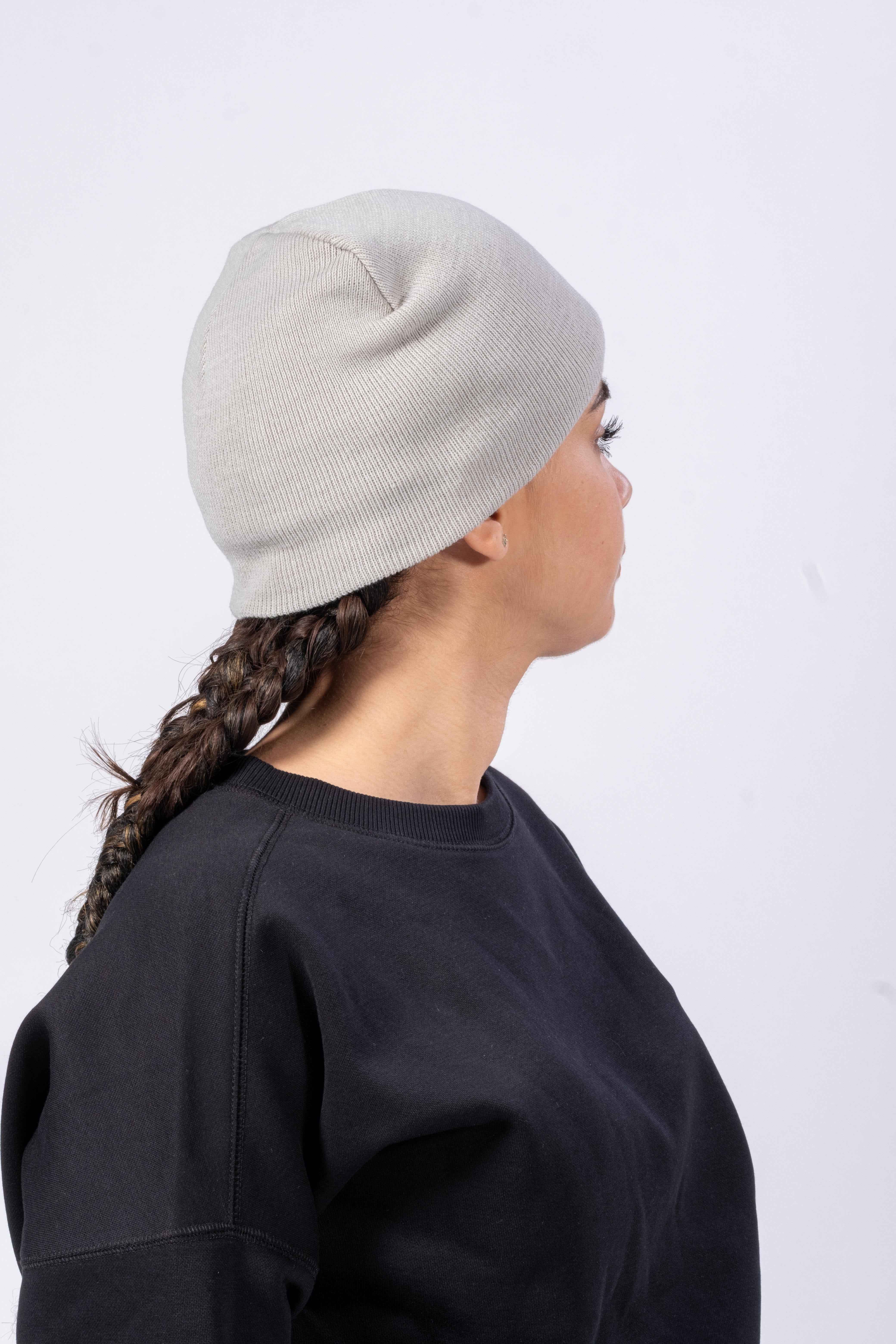 Femme portant un bonnet écoresponsable gris de la marque Rivat, style simple et confortable