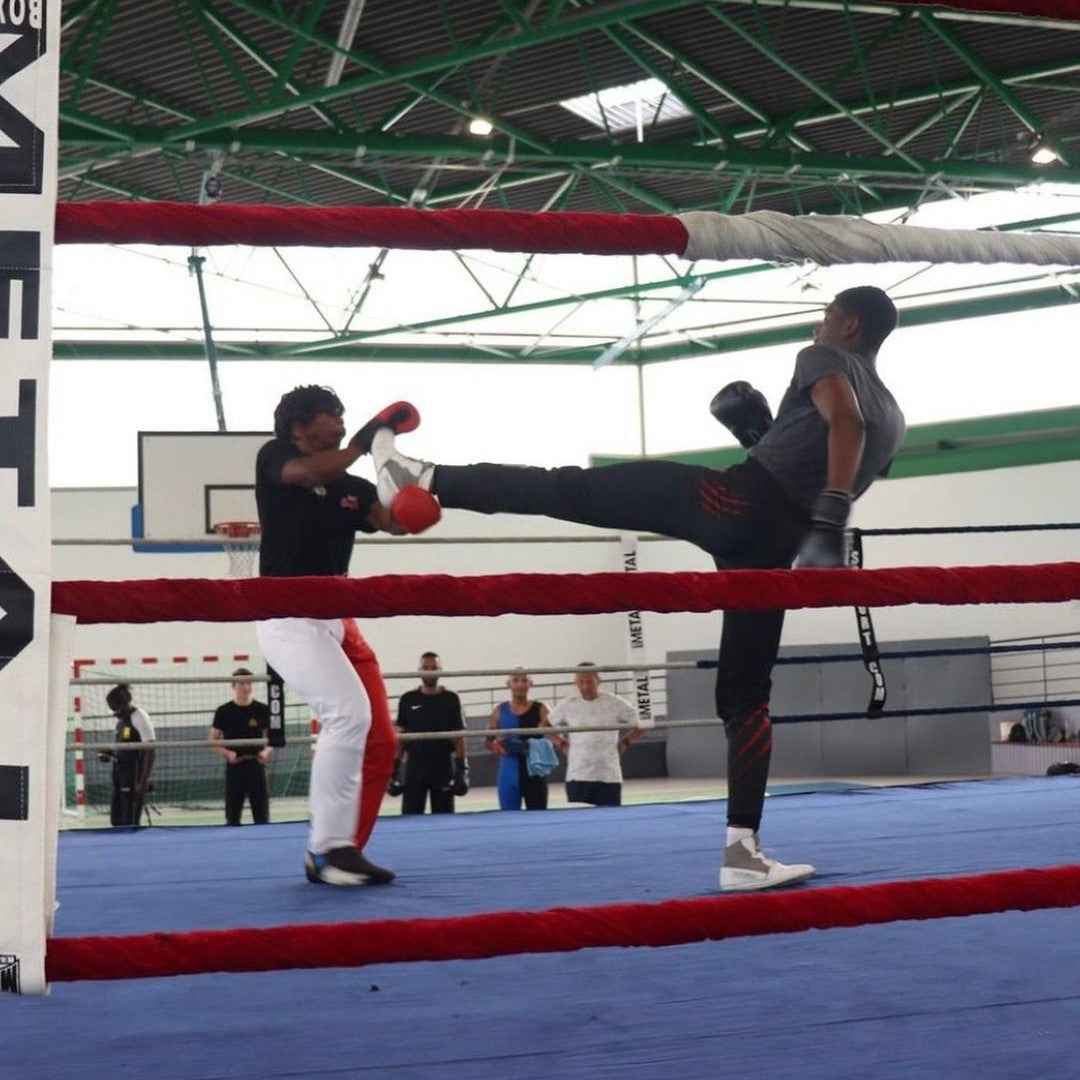 Démonstration des techniques coup de pied bas boxe française dans un entraînement en salle de sport