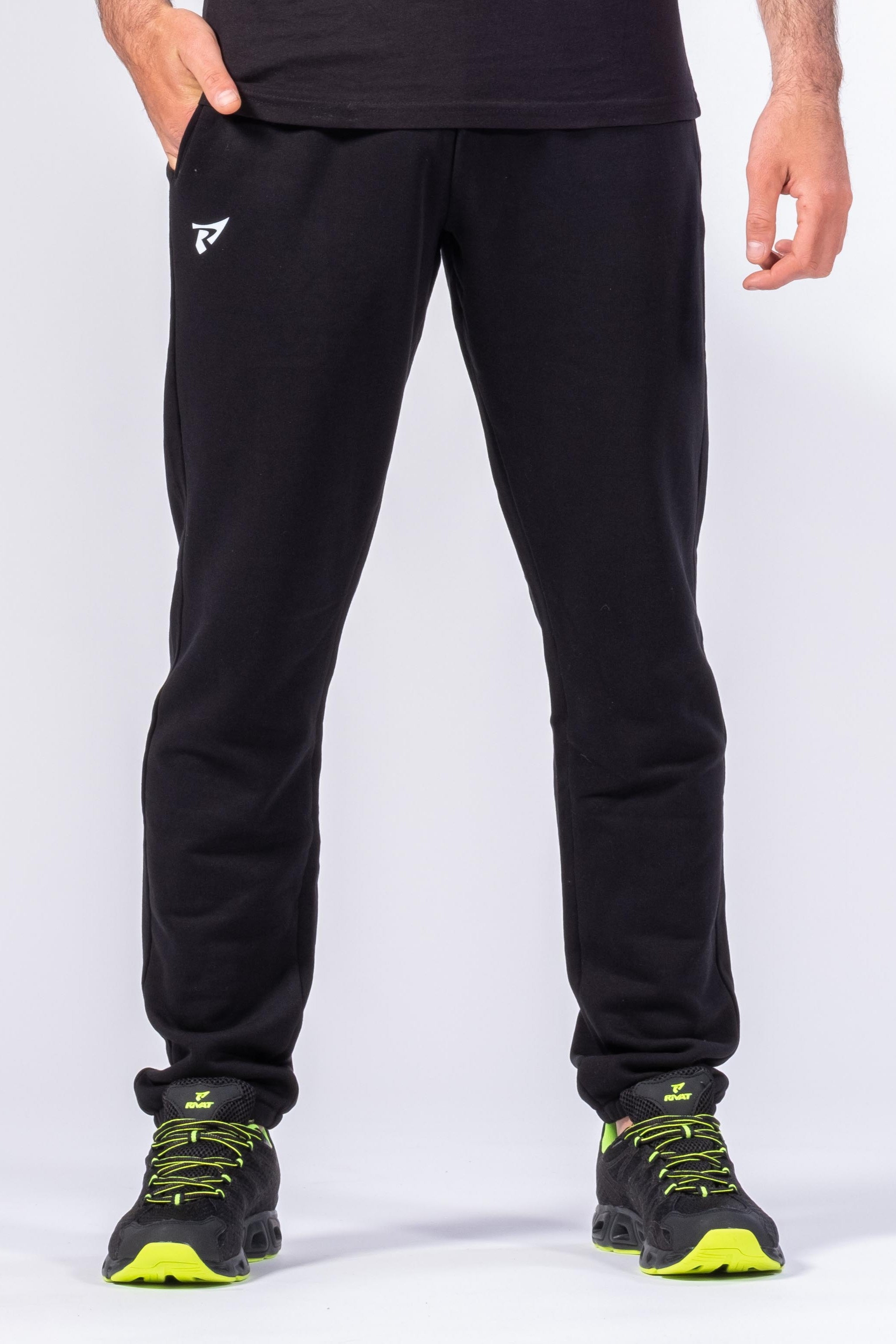 Jogging noir boxe française Rivat porté par un homme avec chaussures de sport noires et vertes