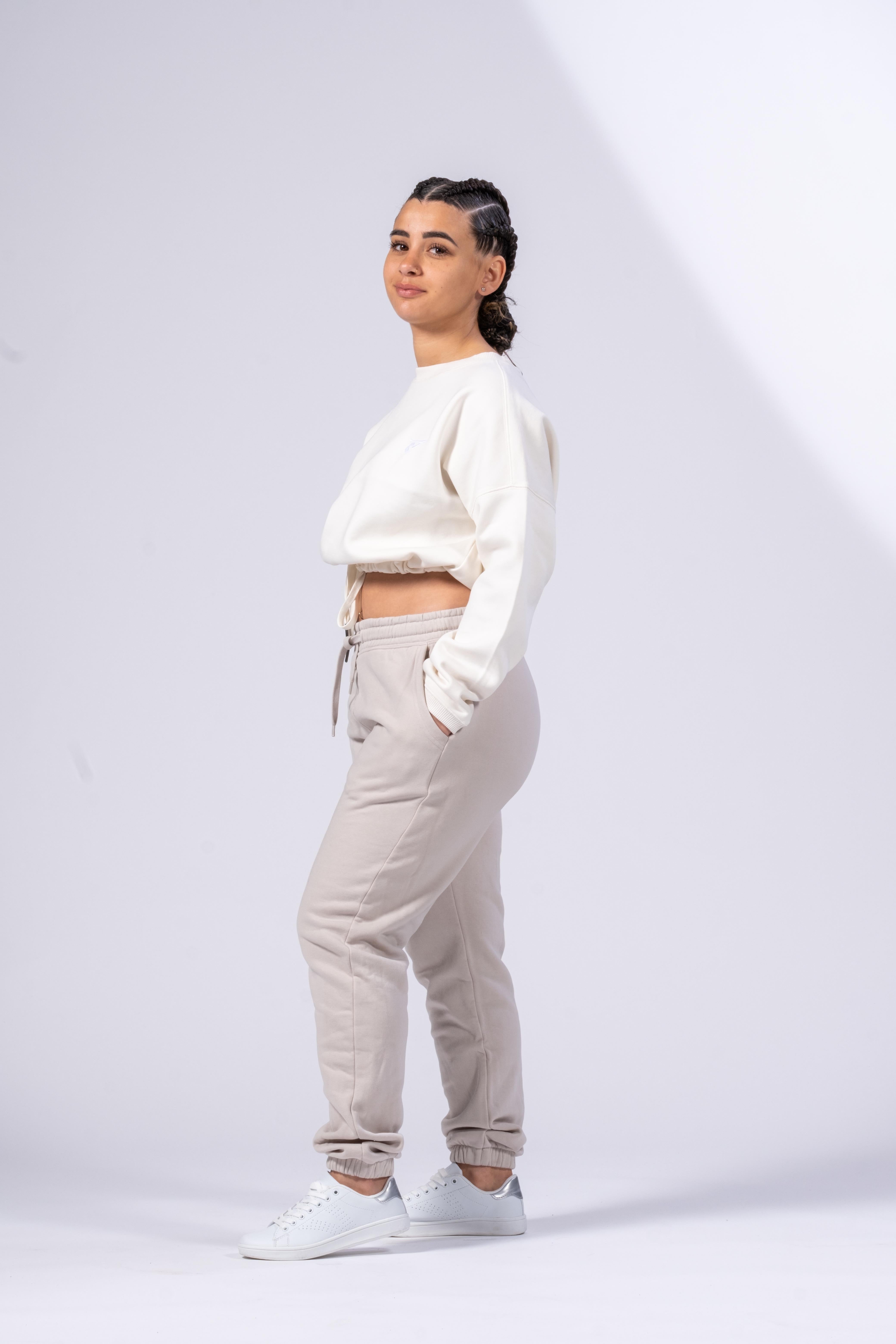 Sweat-shirt oversize femme ivoire porté par une femme avec pantalon beige et baskets blanches